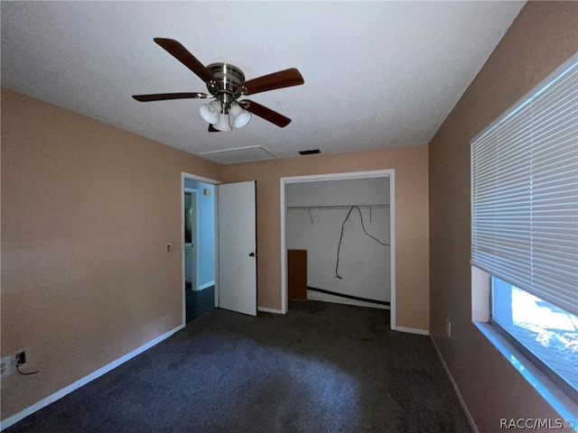 unfurnished bedroom with ceiling fan, a closet, and dark carpet