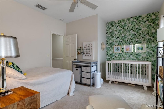 bedroom featuring wallpapered walls, an accent wall, carpet flooring, and a ceiling fan