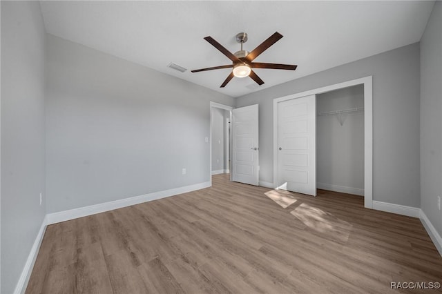 unfurnished bedroom with light hardwood / wood-style flooring, ceiling fan, and a closet