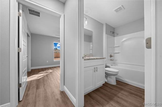 full bathroom with vanity, toilet, hardwood / wood-style floors, and shower / bathing tub combination