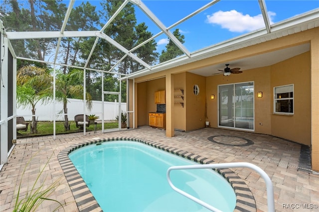 view of swimming pool featuring ceiling fan, a patio area, a lanai, and area for grilling