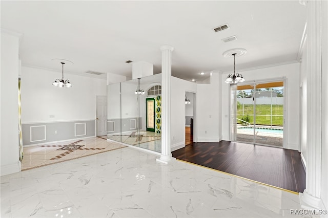 kitchen featuring decorative light fixtures, a healthy amount of sunlight, ornamental molding, and a notable chandelier