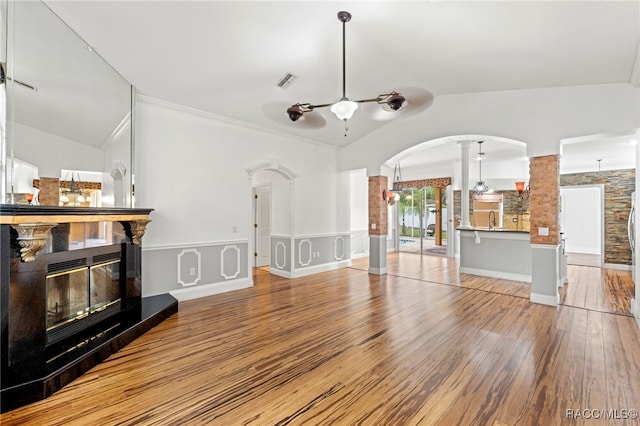 living room with lofted ceiling, ceiling fan, sink, hardwood / wood-style flooring, and decorative columns