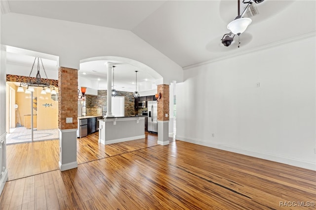 unfurnished living room featuring ceiling fan, ornamental molding, lofted ceiling, and light hardwood / wood-style floors