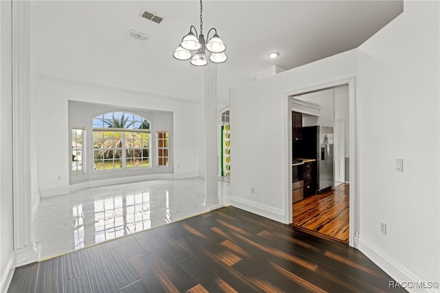 unfurnished dining area with dark hardwood / wood-style floors and an inviting chandelier