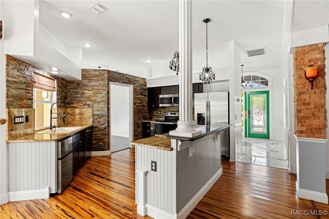 kitchen featuring pendant lighting, a kitchen island, hardwood / wood-style floors, sink, and appliances with stainless steel finishes