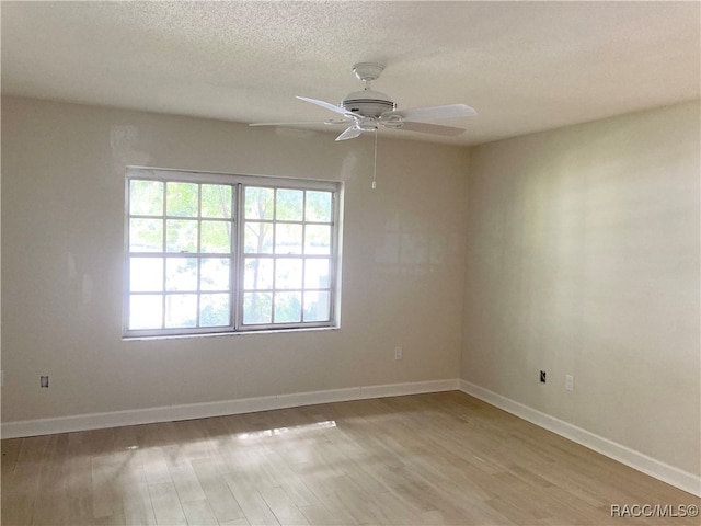 unfurnished room with ceiling fan, light hardwood / wood-style flooring, and a textured ceiling