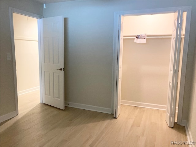 unfurnished bedroom featuring light wood-type flooring and a closet