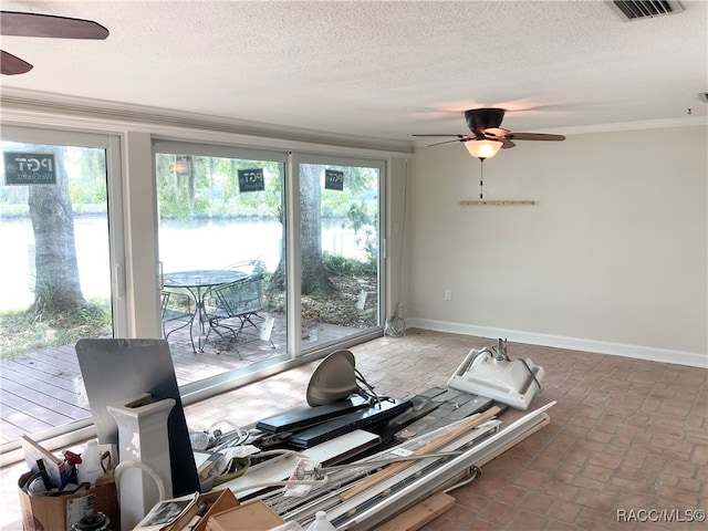 interior space with a textured ceiling, ceiling fan, and crown molding