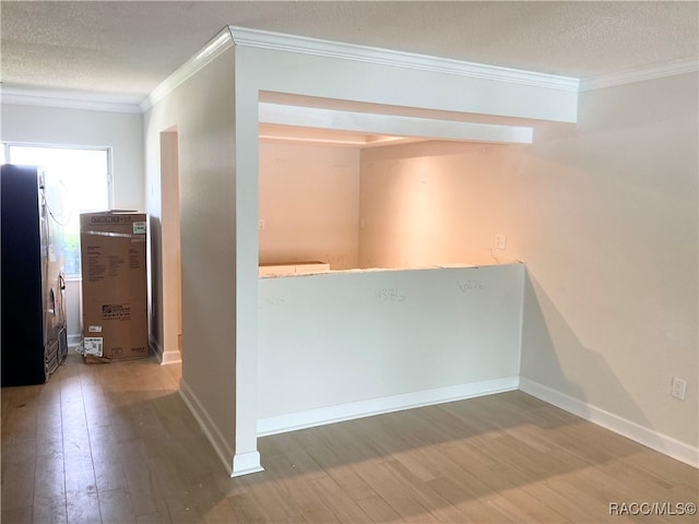 corridor with crown molding, hardwood / wood-style floors, and a textured ceiling