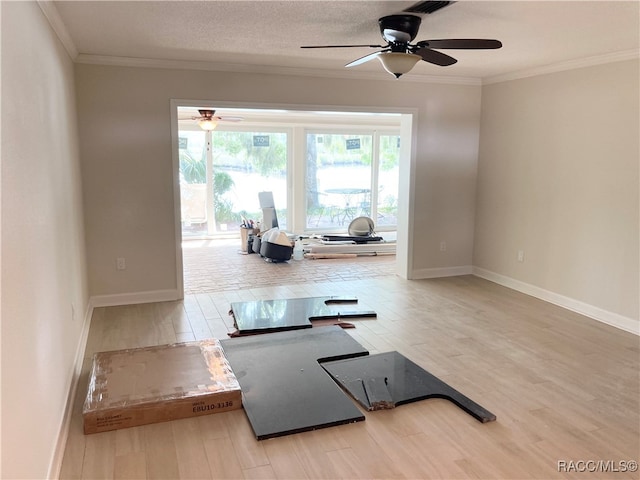 exercise area with a textured ceiling, hardwood / wood-style flooring, ceiling fan, and ornamental molding