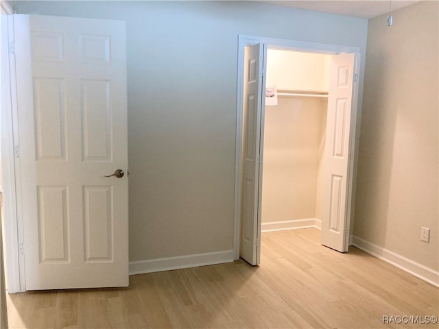 unfurnished bedroom with a closet and light hardwood / wood-style flooring