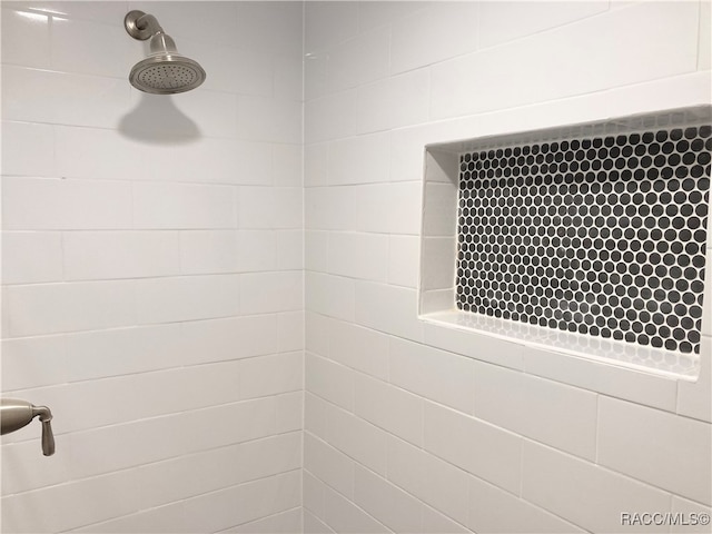 interior details featuring a tile shower