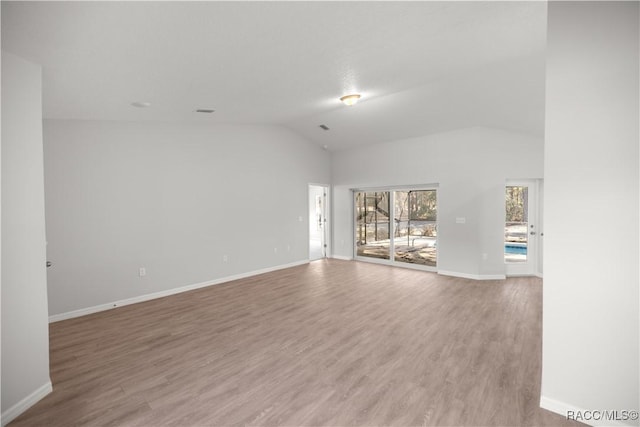 unfurnished room with lofted ceiling and hardwood / wood-style flooring