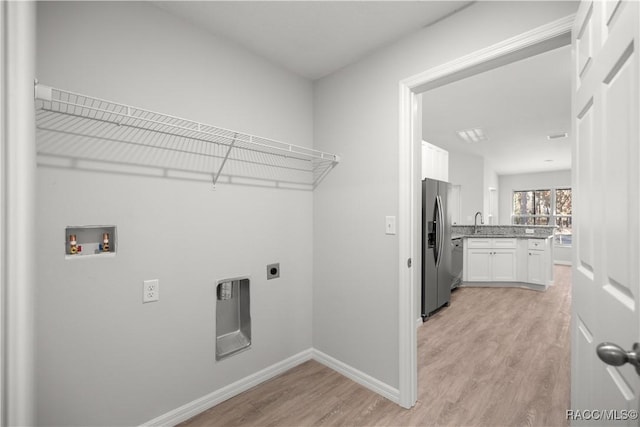 washroom featuring light hardwood / wood-style flooring, hookup for an electric dryer, hookup for a washing machine, and sink