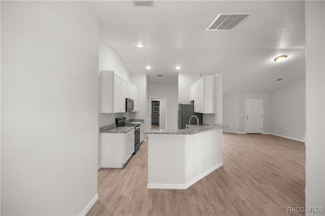 kitchen with light stone counters, white cabinetry, appliances with stainless steel finishes, and light hardwood / wood-style flooring