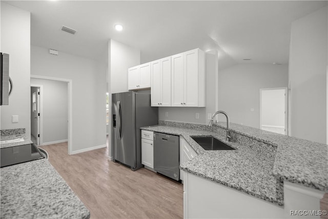 kitchen featuring kitchen peninsula, sink, white cabinetry, light stone countertops, and stainless steel appliances