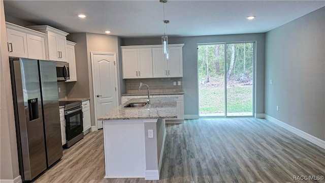 kitchen featuring a sink, backsplash, appliances with stainless steel finishes, baseboards, and white cabinets