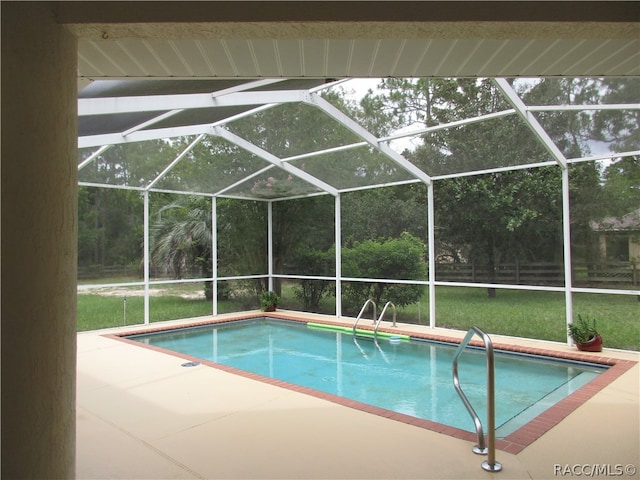 view of swimming pool with glass enclosure and a patio