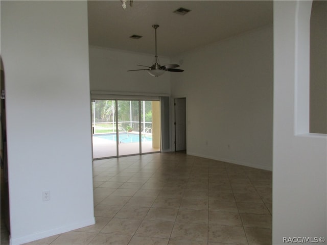 unfurnished room with ceiling fan, light tile patterned floors, and a high ceiling