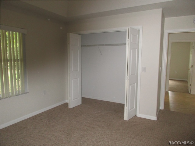 unfurnished bedroom with carpet, a closet, and multiple windows