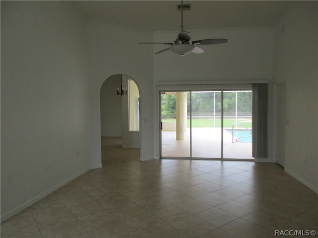 unfurnished room featuring a high ceiling and ceiling fan