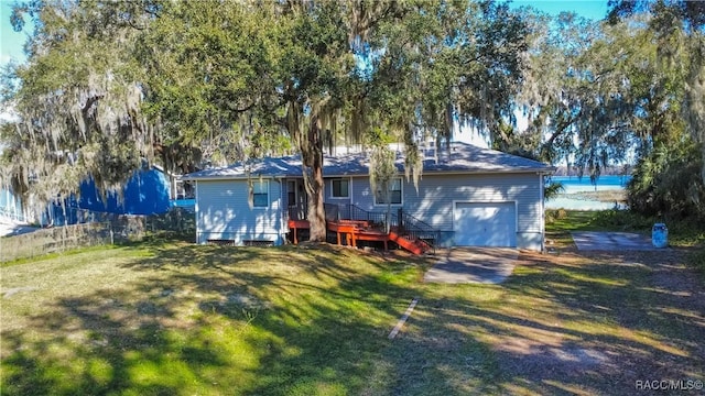 back of property with a garage and a yard