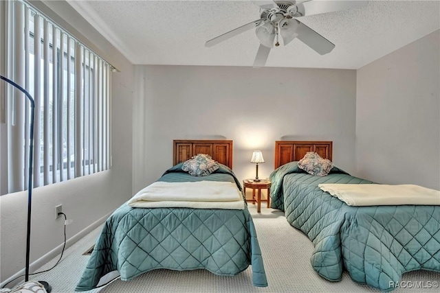 carpeted bedroom featuring ceiling fan and a textured ceiling