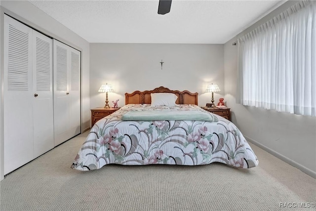 carpeted bedroom with ceiling fan and a closet