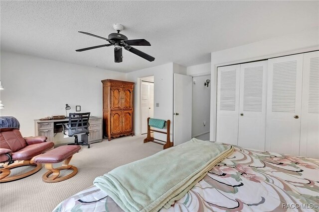 carpeted bedroom featuring a textured ceiling, ceiling fan, and a closet