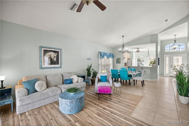 living room featuring visible vents, vaulted ceiling, and a wealth of natural light