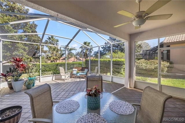 sunroom / solarium featuring ceiling fan