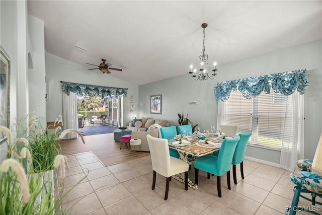 dining area featuring ceiling fan with notable chandelier, visible vents, vaulted ceiling, and light tile patterned floors