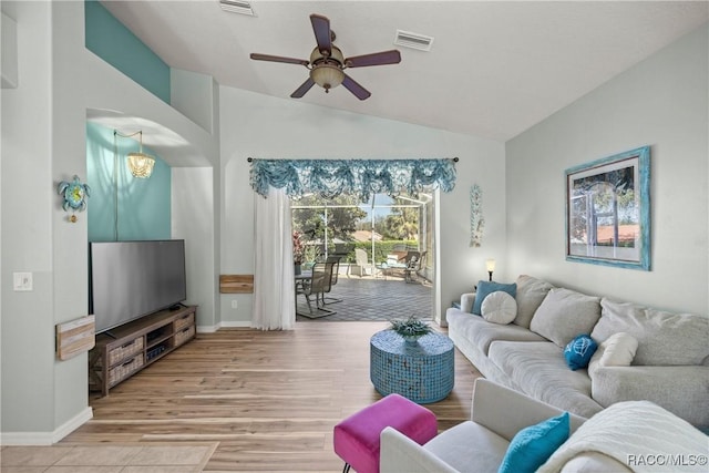 living room with baseboards, visible vents, vaulted ceiling, and light wood finished floors