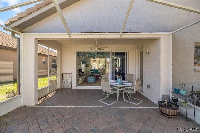 sunroom featuring vaulted ceiling and a ceiling fan