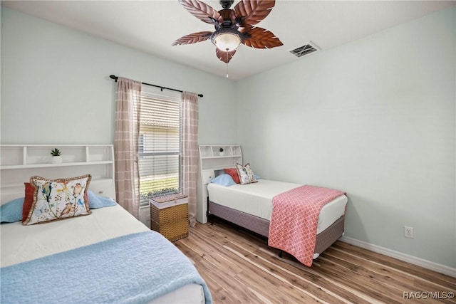 bedroom with visible vents, ceiling fan, baseboards, and wood finished floors