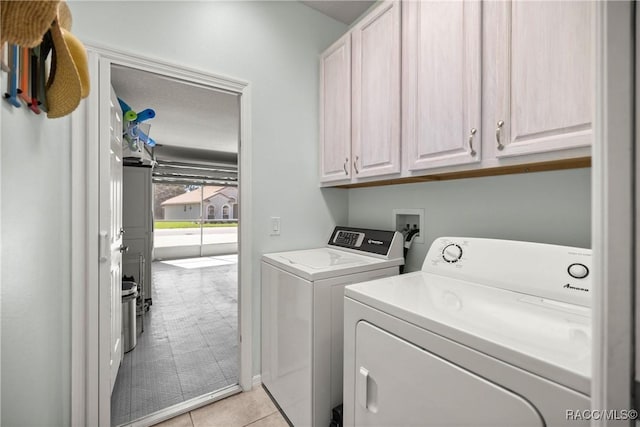 clothes washing area with washing machine and dryer and cabinet space