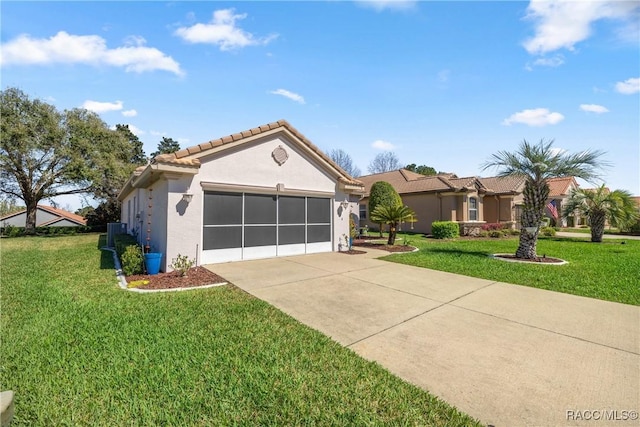 view of front of property with an attached garage, concrete driveway, a tiled roof, stucco siding, and a front lawn