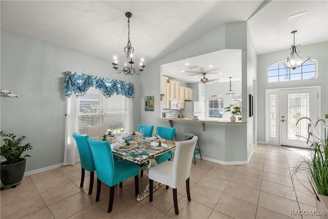 dining space featuring light tile patterned floors, ceiling fan with notable chandelier, and baseboards