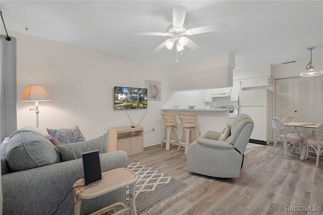 living room with light hardwood / wood-style floors and ceiling fan