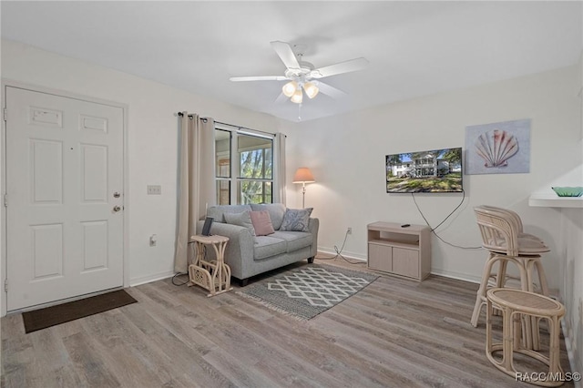 living room featuring ceiling fan and light hardwood / wood-style flooring