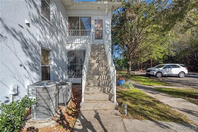 view of exterior entry featuring central air condition unit