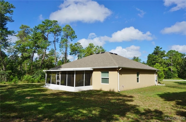 back of house with a lawn and a sunroom