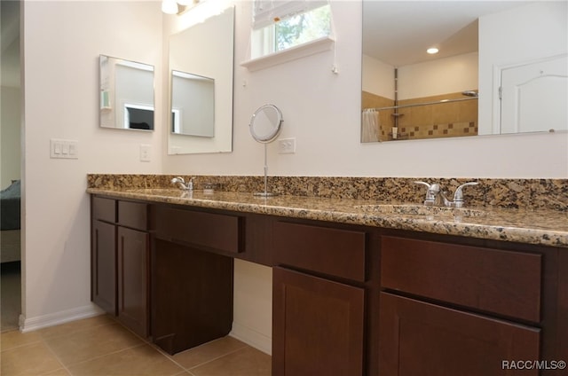 bathroom with tile patterned floors, vanity, and a tile shower