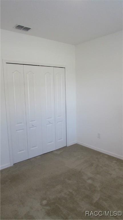 unfurnished bedroom featuring carpet flooring and a closet