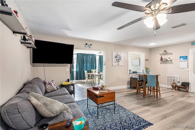 living room with wood-type flooring and ceiling fan