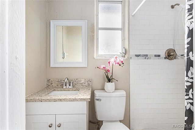 bathroom with vanity, curtained shower, and toilet