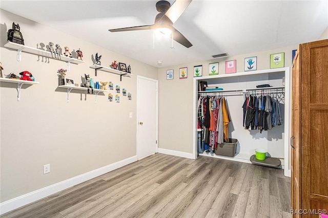 unfurnished bedroom featuring ceiling fan, light hardwood / wood-style floors, and a closet