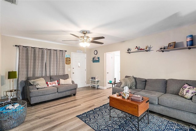 living room featuring wood-type flooring and ceiling fan