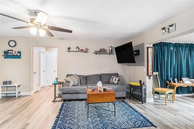 living room with ceiling fan and light hardwood / wood-style flooring